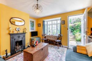 ein Wohnzimmer mit gelben Wänden und einem Kamin in der Unterkunft Tail End Cottage in Rye