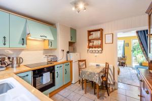 eine Küche mit Tisch und ein Esszimmer in der Unterkunft Tail End Cottage in Rye