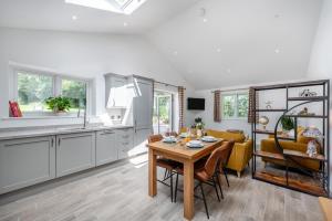 eine Küche und ein Wohnzimmer mit einem Holztisch in der Unterkunft Little Mead in Littleham