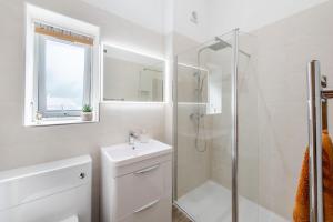 ein weißes Badezimmer mit Dusche und Waschbecken in der Unterkunft Little Mead in Littleham