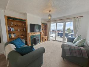 a living room with a couch and a tv and a fireplace at Landfall in Saundersfoot +28 photos