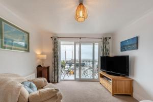 a living room with a flat screen tv and a couch at Landfall in Saundersfoot