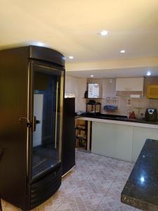 a kitchen with a black refrigerator and a counter at Suíte 8 individual com banheiro privativo em Campinas próximo a rodoviária in Campinas