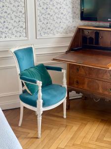 a blue chair sitting next to a wooden desk at VILLA la GLORIETTE in Rouen