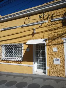 a yellow building with a white door and a window at Suíte 8 individual com banheiro privativo em Campinas próximo a rodoviária in Campinas