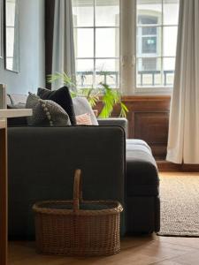 a living room with a black couch and a basket at Steps To Best Bern Sites And Lots Of Space Too! in Bern