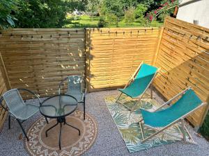 a patio with three chairs and a table and a fence at Love room, Le 827 