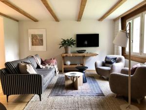 a living room with a couch and two chairs at Waterfall Views-Stylish Design-Big Comfy Bed in Lauterbrunnen