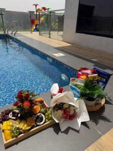 a tray of food next to a swimming pool at Violet Chalett in Jalan Bani Buali