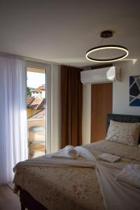 a bedroom with a bed and a large window at Dvor Lux in Novi Pazar