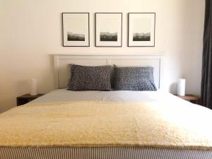 a bedroom with a bed with three pictures on the wall at Modern Apartment with Parking & Great Amenities in Lauterbrunnen