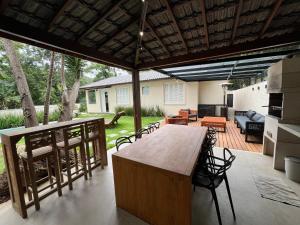 un patio con tavolo e sedie in legno di Casa 09 Floresta Boa Vista - Piscina Privativa, Jardim e Lazer Completo a Teresópolis