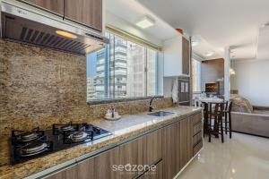 a kitchen with a stove and a counter top at Apto c/ Churrasqueira a 240m da Praia LUP0302 in Itajubá