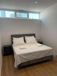 a bedroom with a large bed with white sheets and pillows at The White House Split in Split