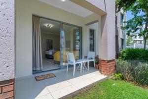 una casa con un patio con mesa y sillas en AlimamaSpaces - The View Studio, en Fourways