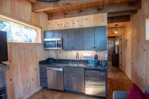 una cucina con armadi blu in una cabina di legno di 1 Mile to Downtown West Jefferson! Camping Cabin #3 a West Jefferson