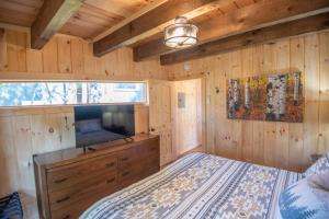 una camera da letto con un letto e una TV a schermo piatto di 1 Mile to Downtown West Jefferson! Camping Cabin #3 a West Jefferson