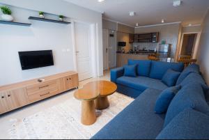 ein Wohnzimmer mit einem blauen Sofa und einem Tisch in der Unterkunft Havn Blue 5002 in El-Alamein