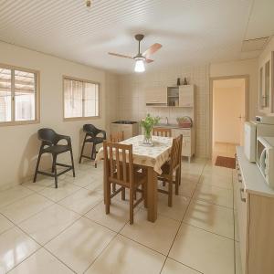 a kitchen and dining room with a table and chairs at Casa Espaçosa 3quartos Piscina Churrasqueira Estacionamento in Canoas