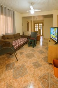 a living room with a couch and a flat screen tv at Casa Espaçosa 3quartos Piscina Churrasqueira Estacionamento in Canoas