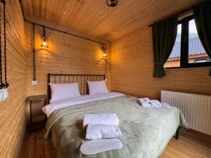 卡兹贝吉Oto Twins Cottages的卧室里有一张大床，床上铺着毛巾。