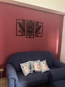 un canapé bleu contre un mur rouge avec quatre oreillers dans l'établissement Victoria, à Salta