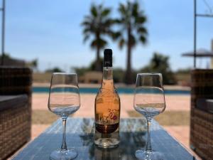 two wine glasses on a table with a bottle of wine at La Casa Montana in Urcal