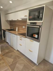 a kitchen with a microwave on top of a oven at Maison Ethno Chic proche de Paris et d'Orly in Morangis +8 photos