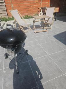 a grill and two chairs and a table on a patio at Maison Ethno Chic proche de Paris et d'Orly in Morangis