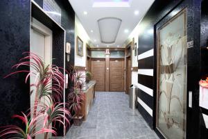 Un pasillo con plantas en macetas en un edificio. en Hotel O Ishita Residency, en Amritsar