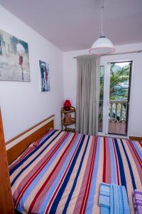 1 dormitorio con cama de rayas y ventana en Apartments Beachfront, en Kotor