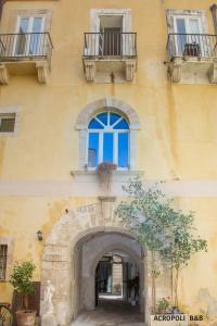 een geel gebouw met een raam en een boog bij Residence Acropoli in Siracusa