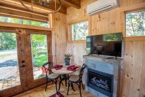 a dining room with a fireplace and a tv at 1 Mile to Downtown West Jefferson Camping Cabin #1 in West Jefferson