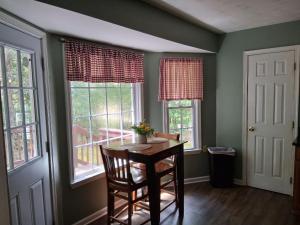 a dining room with a table and two windows at Old Wagon Lodge Spacious Retreat WiFi & Hot Tub Theater Room in Luray +20 photos
