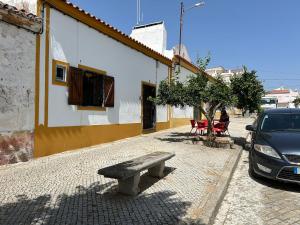 a bench sitting on a sidewalk next to a building at Ninho da Cegonha Assumar in Assumar