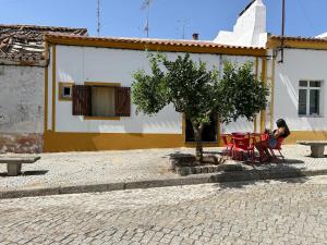 a woman sitting at a table in front of a building at Ninho da Cegonha Assumar in Assumar +4 photos