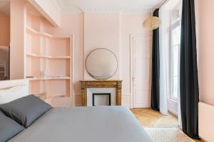 a bedroom with a bed and a mirror on the wall at Lovely - balnéo confort absolu -Parking in Saint Etienne