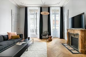 a living room with a couch and a fireplace at Lovely - balnéo confort absolu -Parking in Saint Etienne