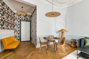 a living room with a table and chairs at Lovely - balnéo confort absolu -Parking in Saint Etienne