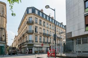 a large building on a street in a city at Lovely - balnéo confort absolu -Parking in Saint Etienne