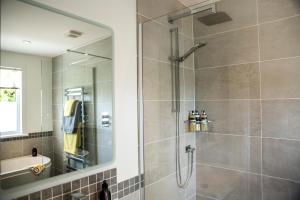 a bathroom with a shower with a glass door at Loch Cottage in Boat of Garten