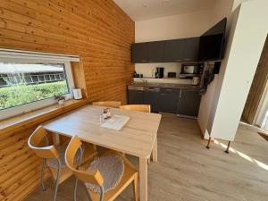 a kitchen and dining room with a wooden table and chairs at Tinyhaus Arendsee in Seenähe in Arendsee