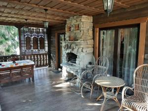 a porch with chairs and a stone fireplace at Видовий !!! in Palyanytsya