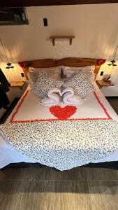a bedroom with a bed with a white and red blanket at Miradouro São Pedro da Serra in São Pedro da Serra