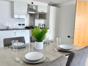 - une table à manger avec des assiettes et de l'argenterie dans l'établissement York City Centre 2-Bed Apartment with Balcony Views Close to Christmas Market, à York