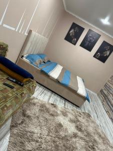 a small bedroom with a bed and a rug at 1-комнатная квартира студия in Ekibastuz