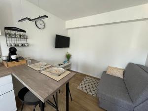 a kitchen and living room with a table and a couch at Alany Apartment Zagreb in Zagreb