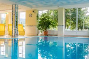 a swimming pool in a building with yellow chairs at Florianihof in Miesenbach