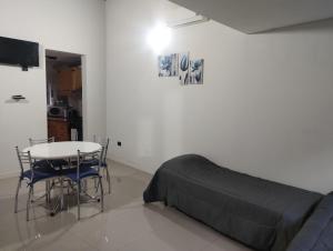 a bedroom with a bed and a table and chairs at Adrogué Apart C in Adrogue
