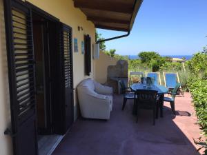 a room with a table and chairs on a patio at Goddess Yard in Tropea